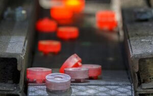 Tempered pieces of steel cooling off as they're transported via conveyor belt.